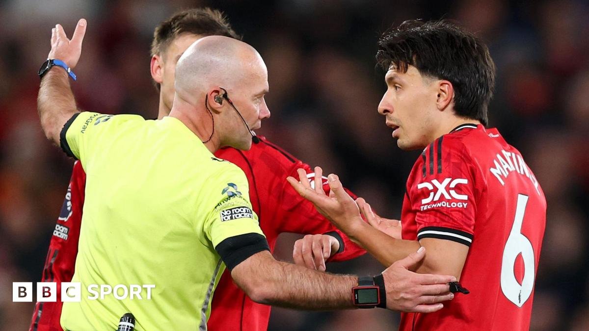 Referee Paul Tierney speaks with Lisandro Martinez of Manchester United after showing him a red card for pulling the hair of Dominic Calvert-Lewin of Leeds United