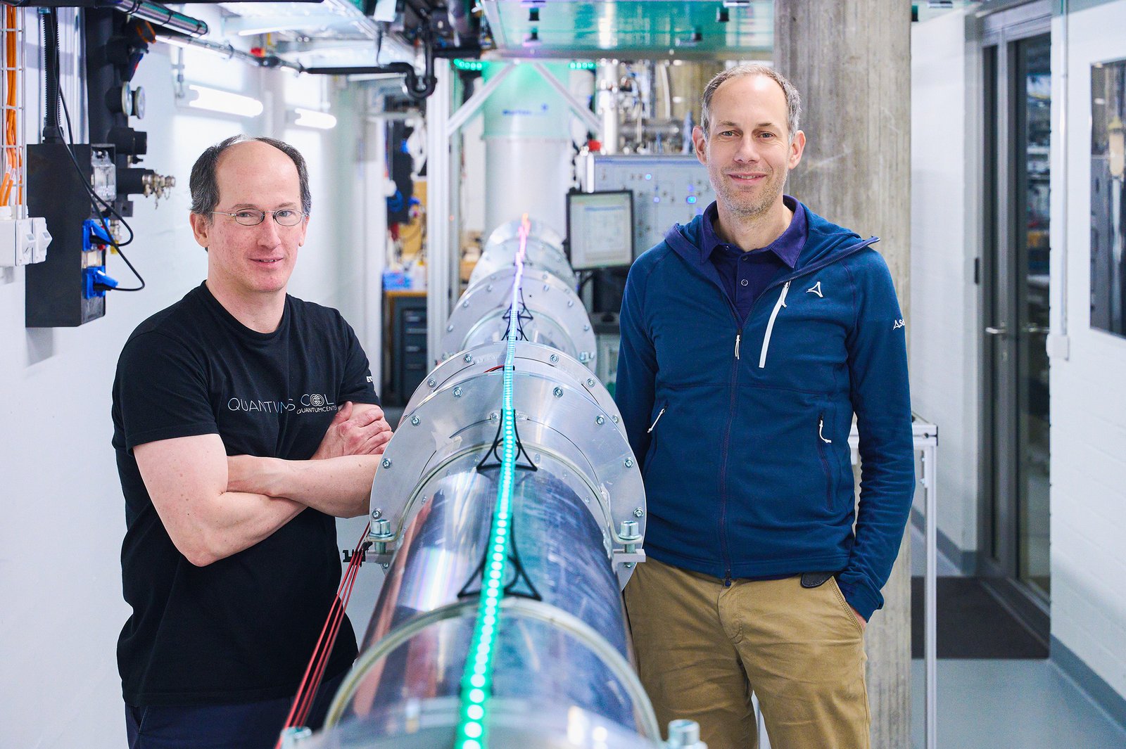 On the left is Andreas Wallraff and on the right is Renato Renner, standing next to the 30-metre-long connection between two quantum chips.