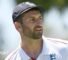 Mark Wood, wearing a blue England cap, looks to the side