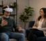 A man wearing a VR headset gestures while seated in a therapist’s office
