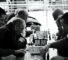 Black and white photograph of seven men playing chess