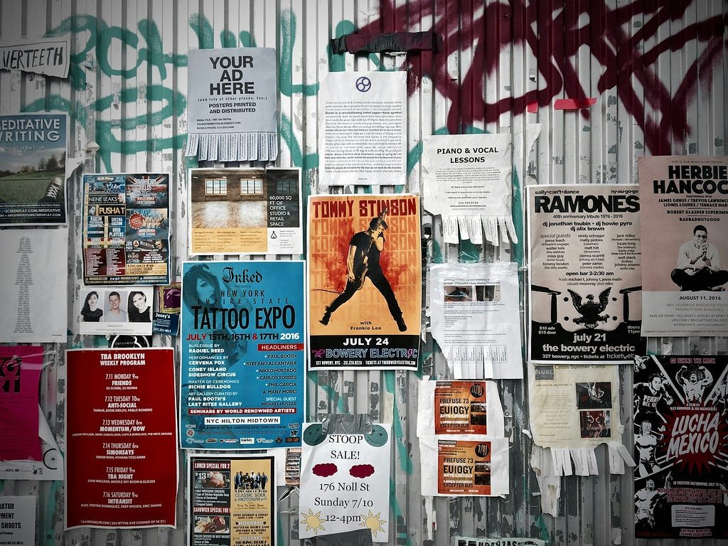 Photograph of a wall with assorted handmade and amateur flyers